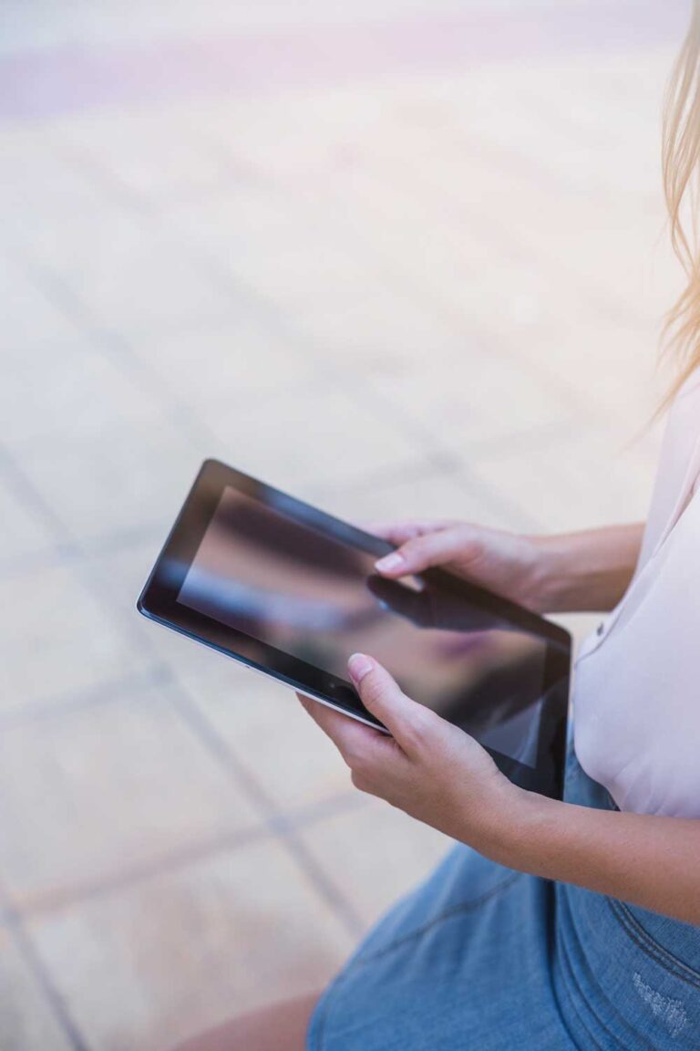 Manos de chica joven sostienen un ipad.
